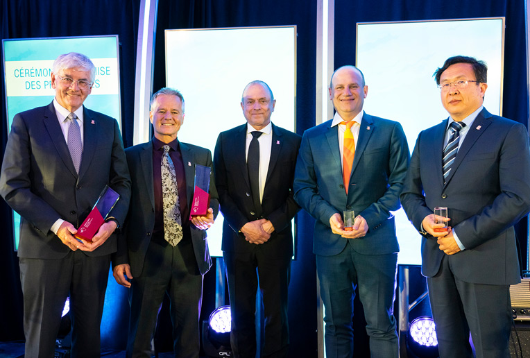 4 récipiendaires qui reçoivent un trophée de Michel Gendron, doyen